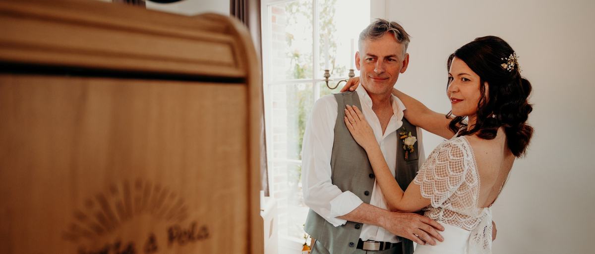 Les mariés devant la borne gravée du logo La Boîte à Pola
