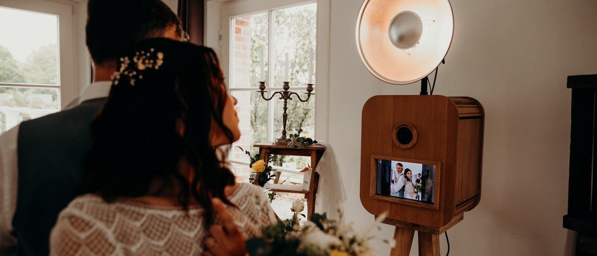 Des mariés devant la borne photo, la photo s'affiche à l'écran